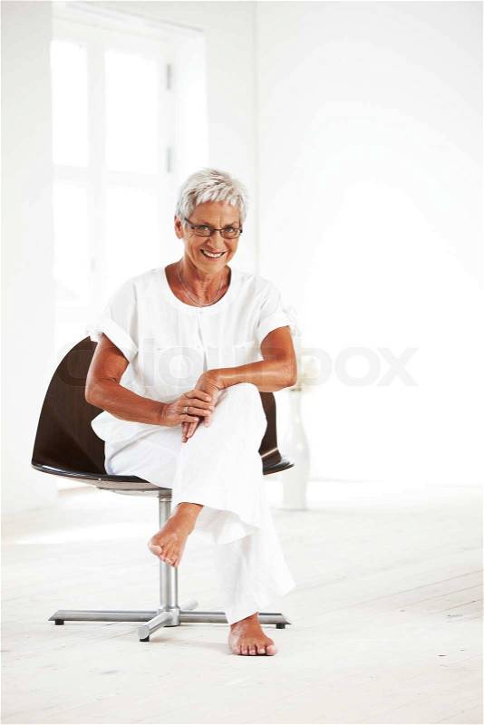 An elderly caucasian woman sitting on chair, stock photo