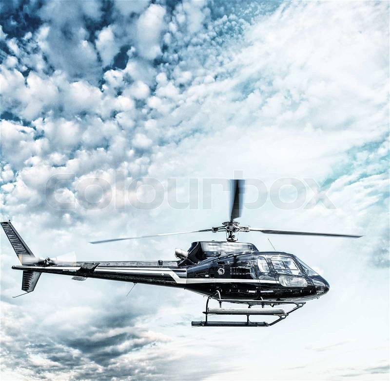 Helicopter flying against the blue sky, stock photo