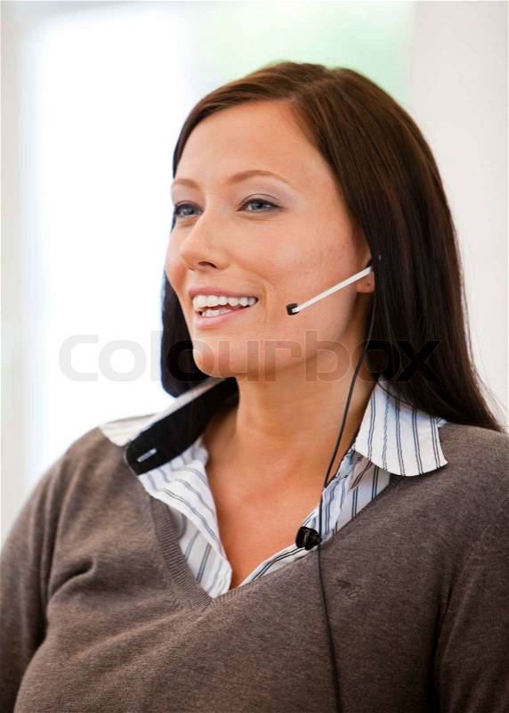 Businesswoman in the customer care or sales departement talking to customers/ clients, stock photo