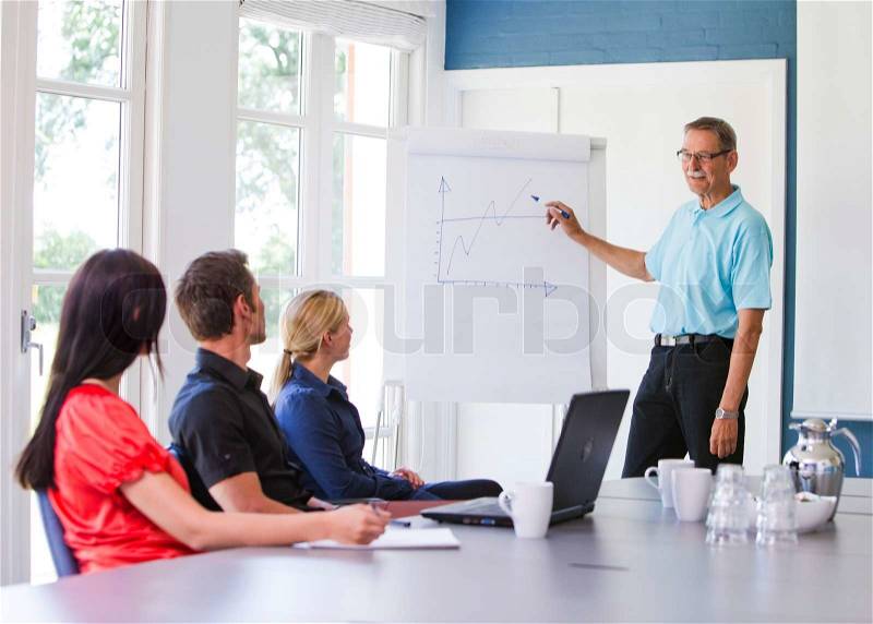 Business people having a meeting/ conference using a whiteboard and a laptop to explain the topics, stock photo
