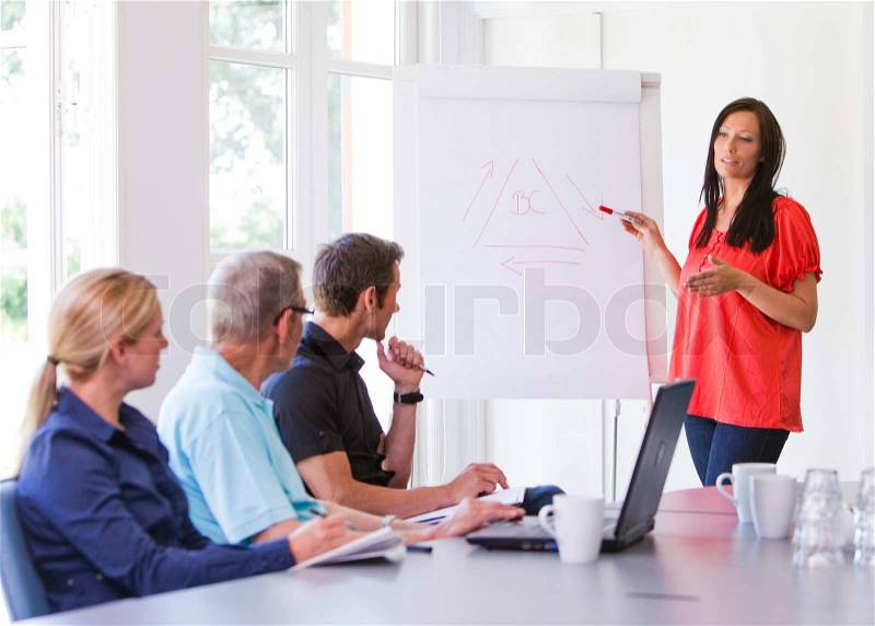 Business people having a meeting/ conference using a whiteboard and a laptop to explain the topics, stock photo