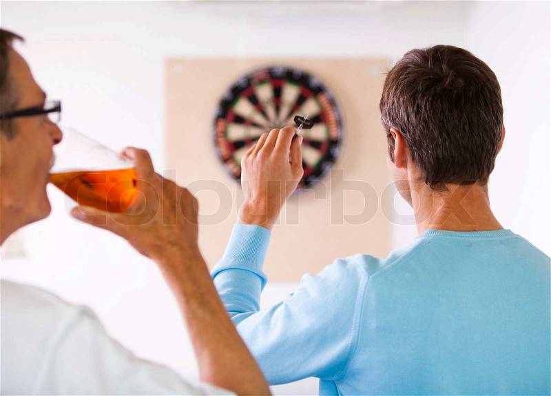 Business people playing dart in a break room at the office. Business people having fun i the break/ recreation room, stock photo