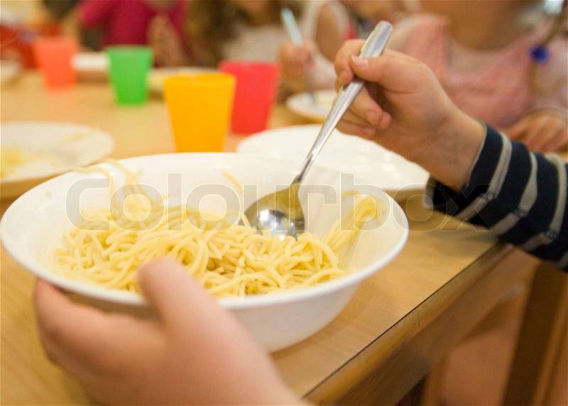 Cropped image of a boy eating a bowl of pasta, stock photo