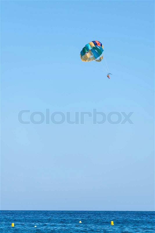 A parachute being towed at sea with a clear blue sky and sea in the background, stock photo