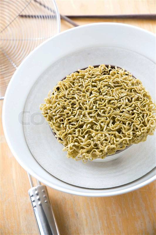 Green instant noodles in white bowl, stock photo