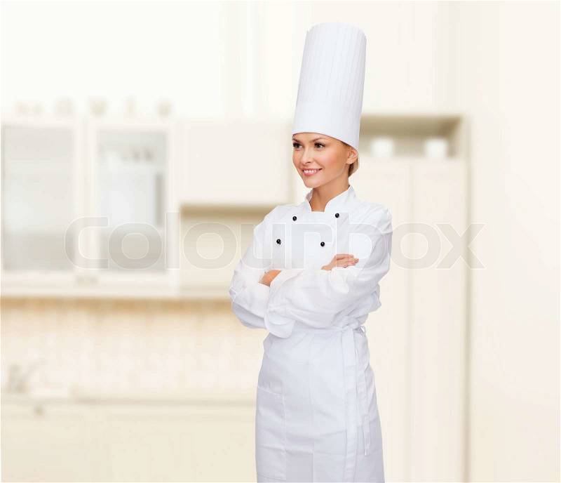 Cooking and food concept - smiling female chef with crossed arms, stock photo