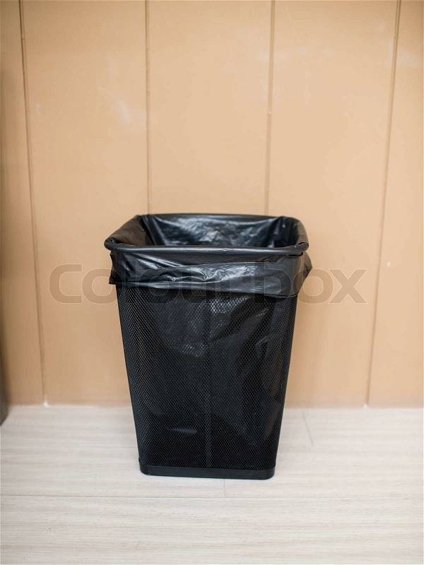 Metal trash with bag with brown wall, stock photo