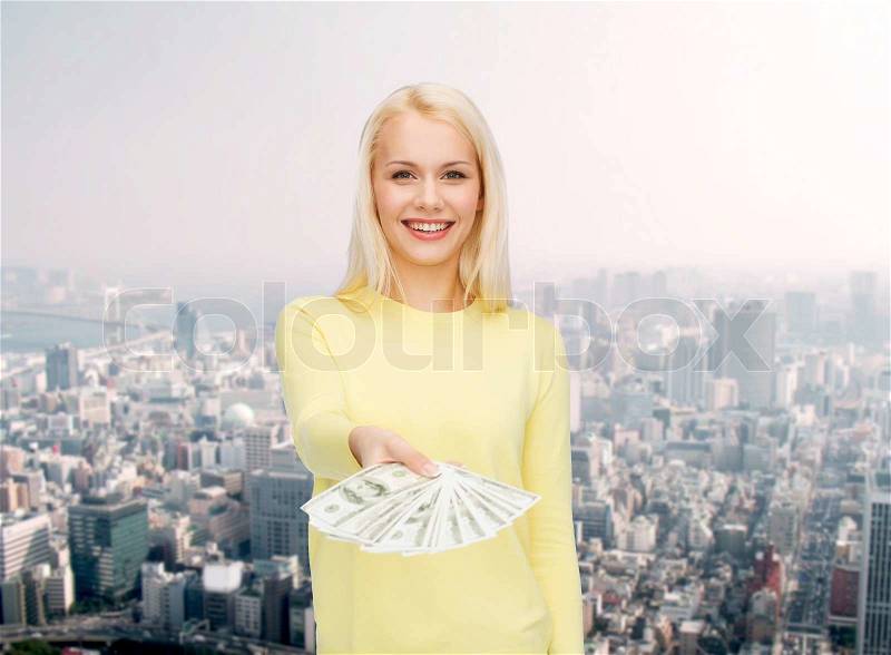 Money, finances and people concept - smiling girl with dollar cash money, stock photo