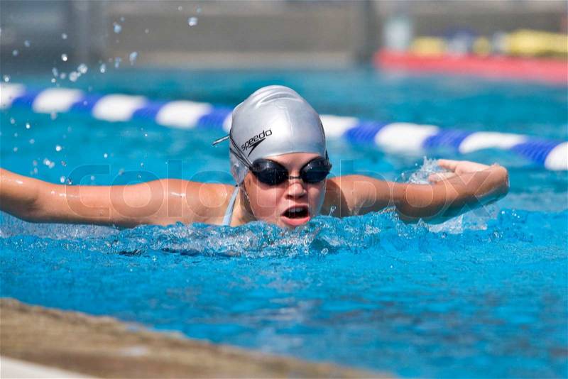 Teenage girl competing in a swimming competition, stock photo