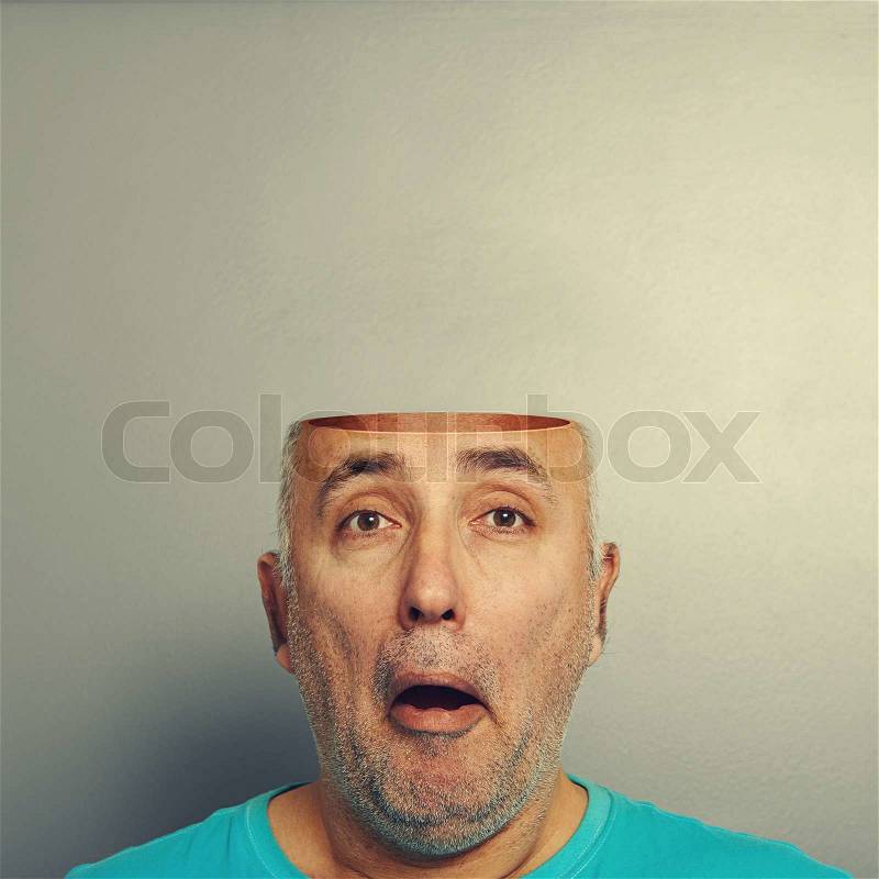 Concept photo of amazed senior man with open head over grey background, stock photo