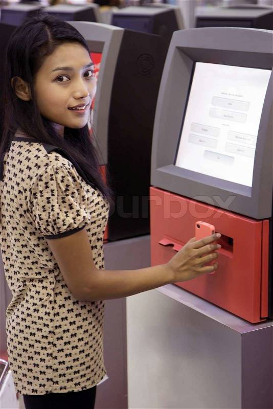 Womanl doing self-check-in in the airport, stock photo
