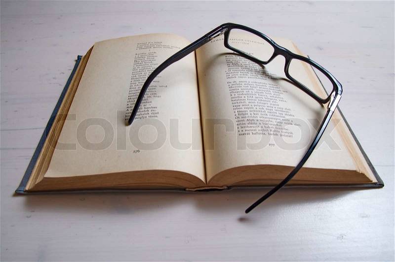 Reading glass on an old book, stock photo
