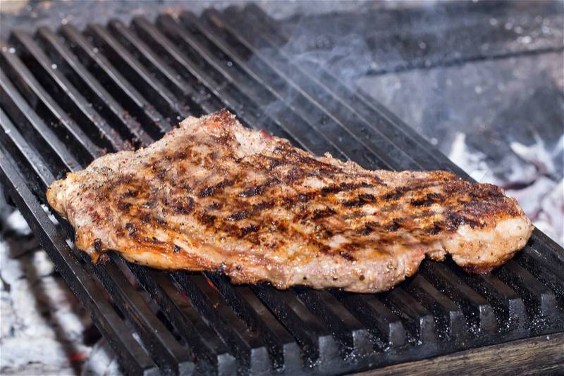 Large beef steak cooked on a grill in the restaurant on the grill, stock photo