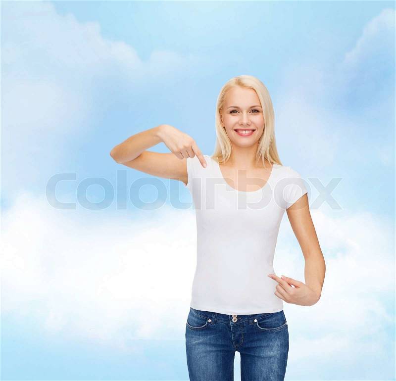 T-shirt design concept - smiling young woman pointing finger to blank white t-shirt, stock photo