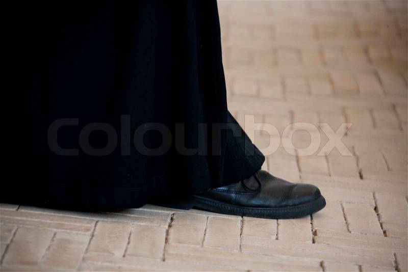 Priest walking on church floor, stock photo