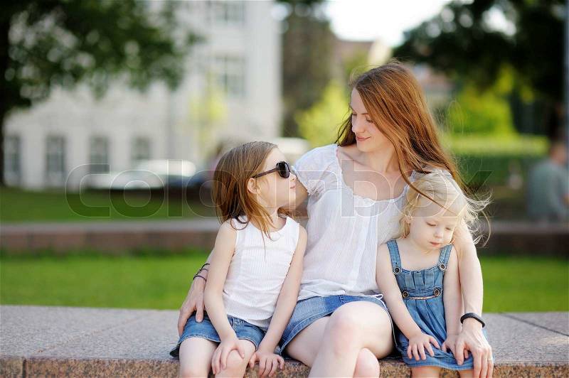 Young mother and her daughters outdoors at summer, stock photo