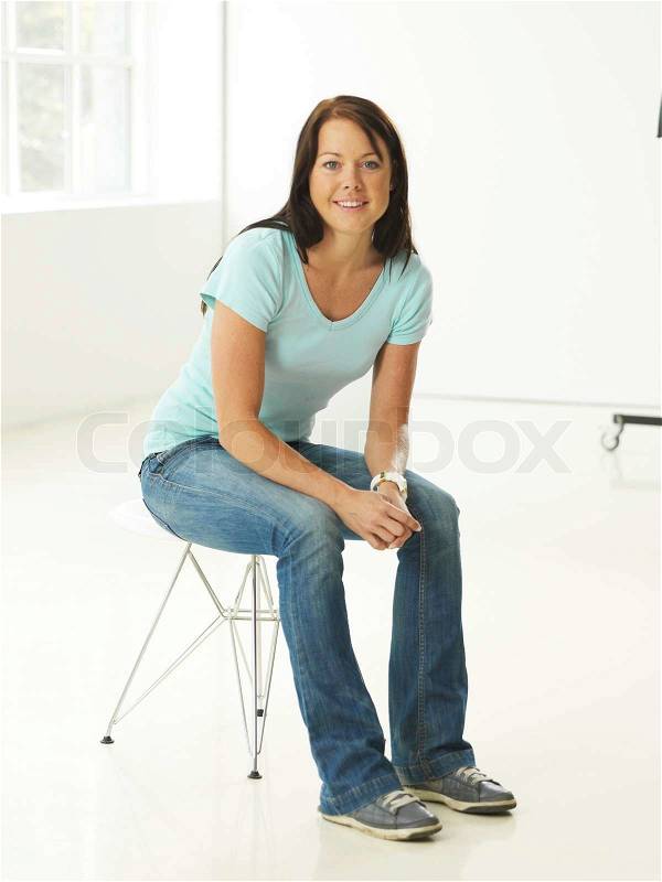 A casual caucasian woman sitting on a chair, stock photo