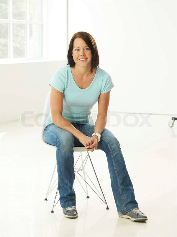 A very relaxed-looking caucasian woman sitting on a chair, stock photo