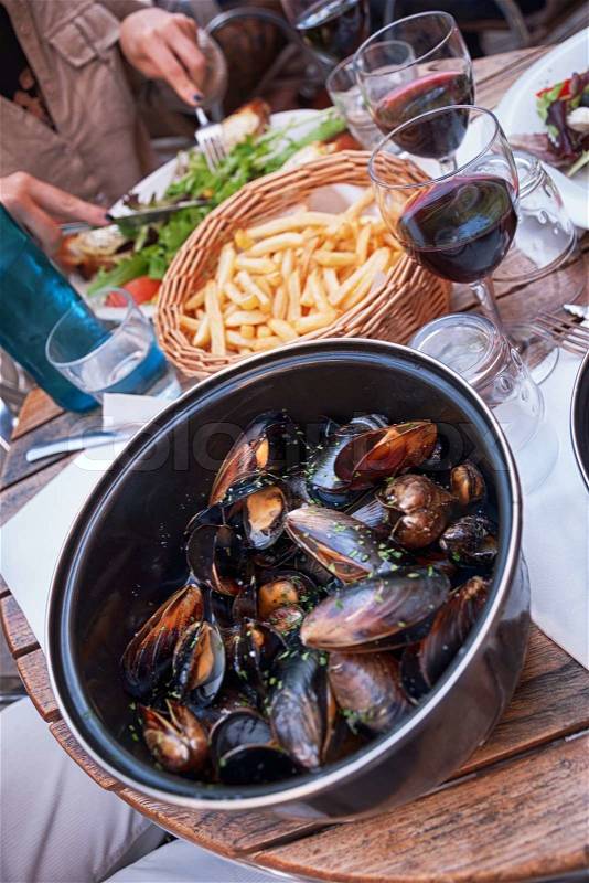 Steamed mussels with fries and wine, french dinner, stock photo