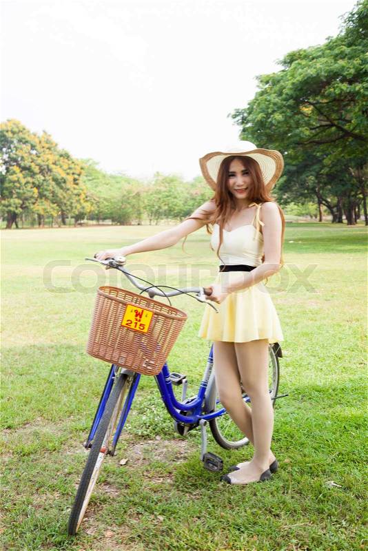 Woman bike handles Strolling on the grass in the park, stock photo
