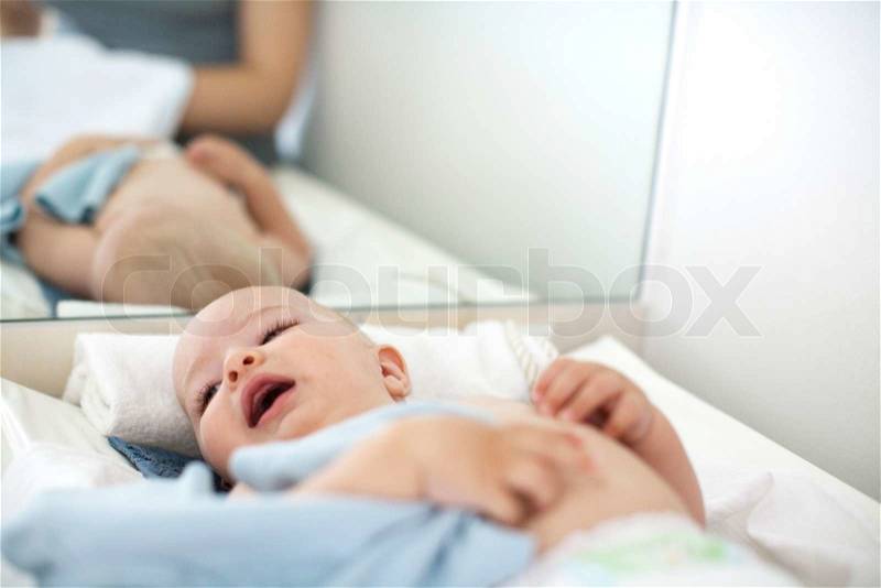 A baby boy who needs a nappy change, stock photo