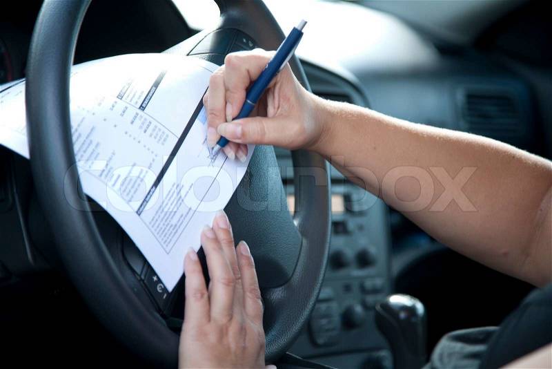 A man filling up a car registration form, stock photo