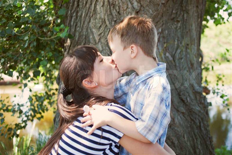 Mother and son kissing outdoor. Happy family concept, stock photo