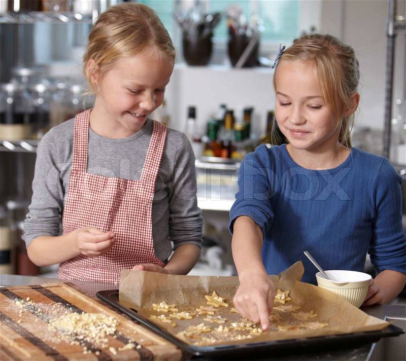 Two sisters making some Christmas cookies, stock photo