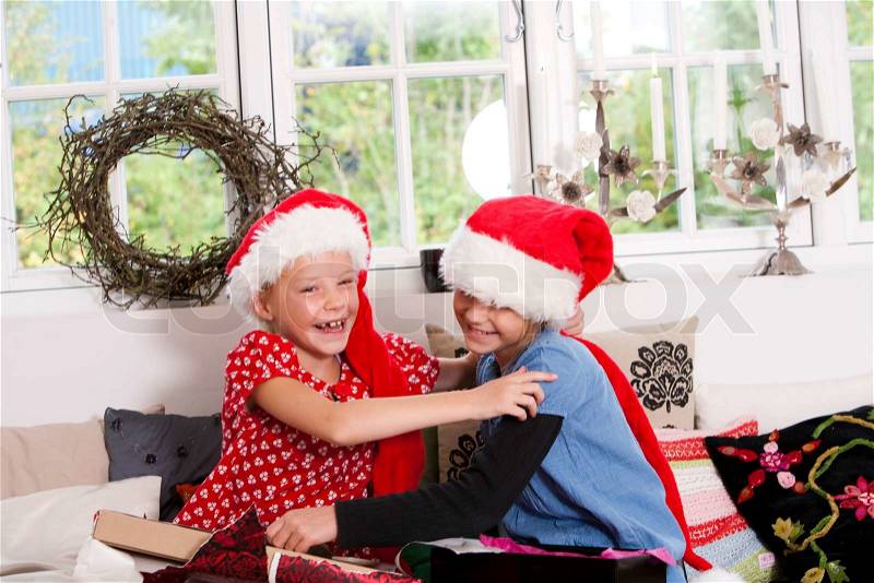 Two happy caucasian girls sharing Christmas presents, stock photo
