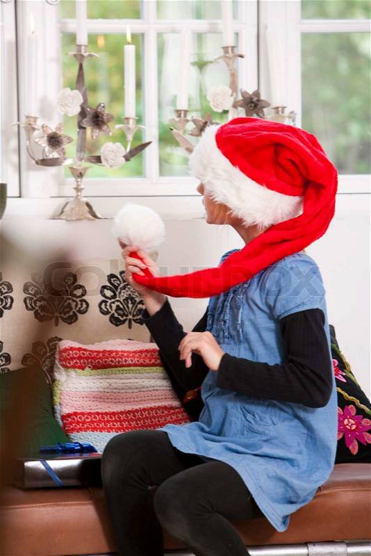 A caucasian girl holding her Santa hat on Christmas day, stock photo