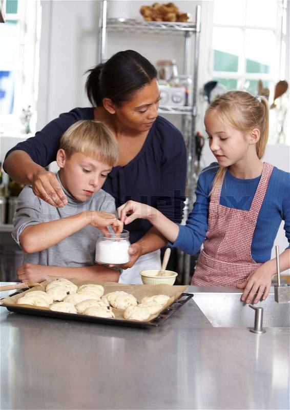 A female teacher teaching children how to bake, stock photo