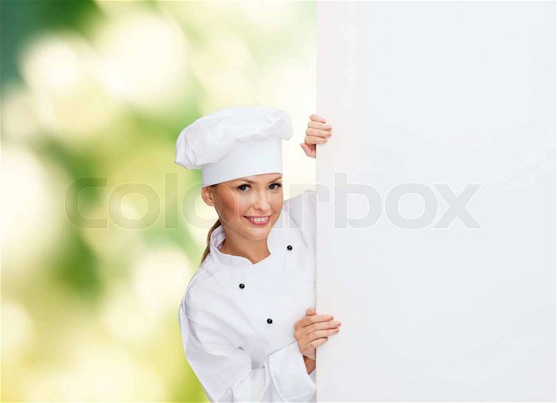 Cooking, advertisement and food concept - smiling female chef, cook or baker with white blank board, stock photo