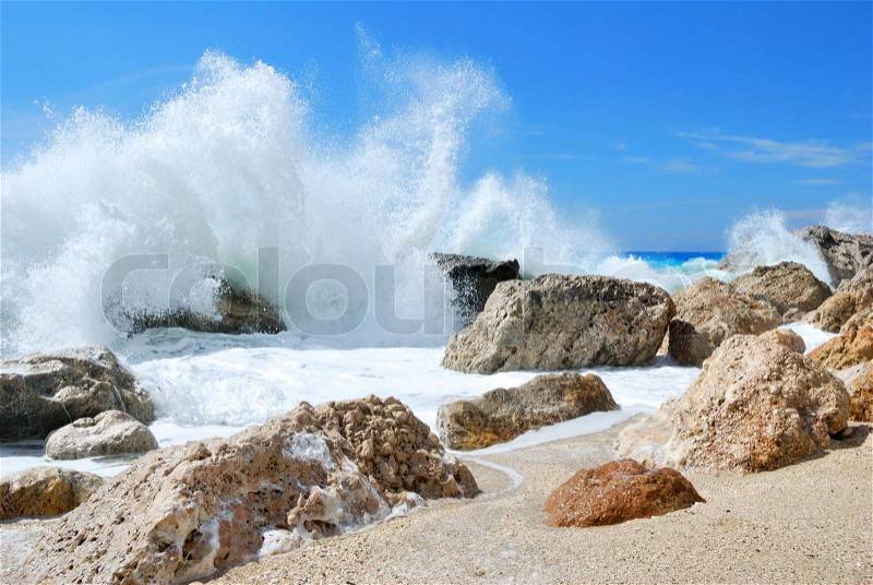 Big sea wave splashing over the shore rocks with a high sea spray, stock photo