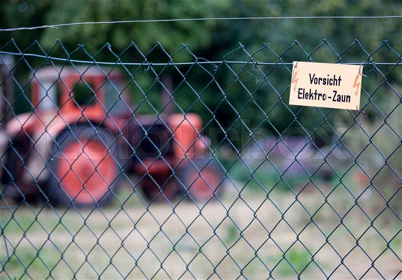 Electric fence warning in german, stock photo