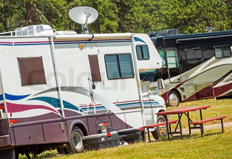 RV Motorhomes Camping. Recreation Vehicles on the Campground. Class C and Class A Diesel Motorhome in the Background, stock photo