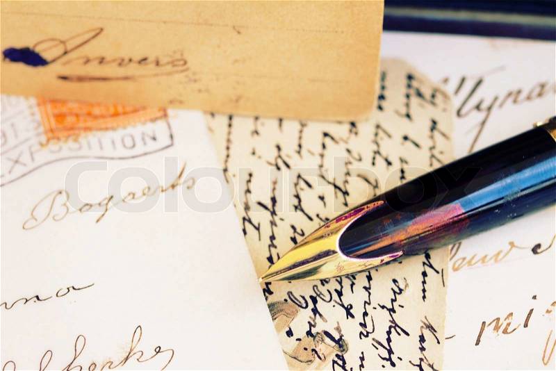 Old retro golden quill pen and antique letters, stock photo