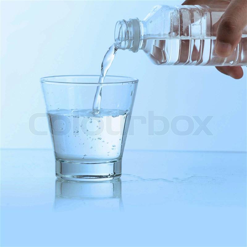 Pouring water into glass, stock photo