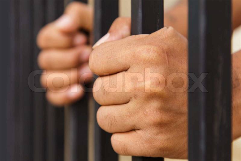 Hand on cage, stock photo