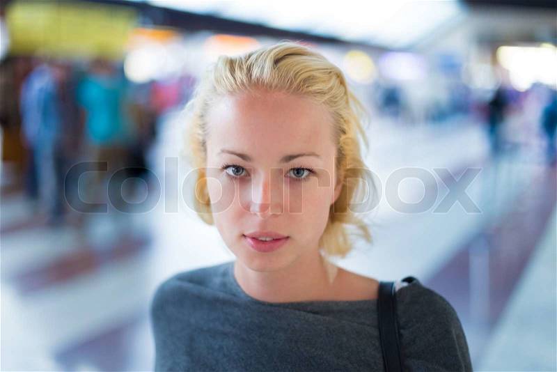 Young woman waiting on the platform of a railway station for their train. to arrive, stock photo