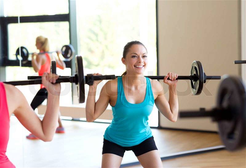 Fitness, sport, training and lifestyle concept - group of women with barbells in gym, stock photo