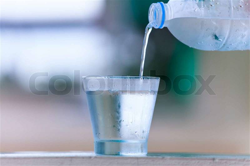 Pouring water on glass, stock photo