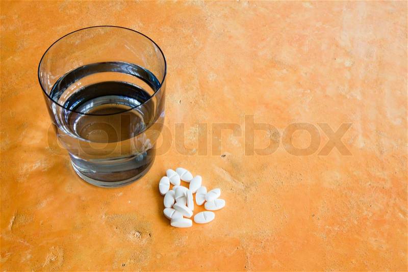 Painkiller tablets and a glass of water, stock photo