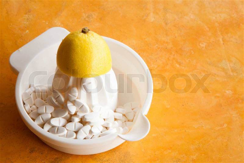 A lemon squeezer and bunch of vitamin supplements, stock photo
