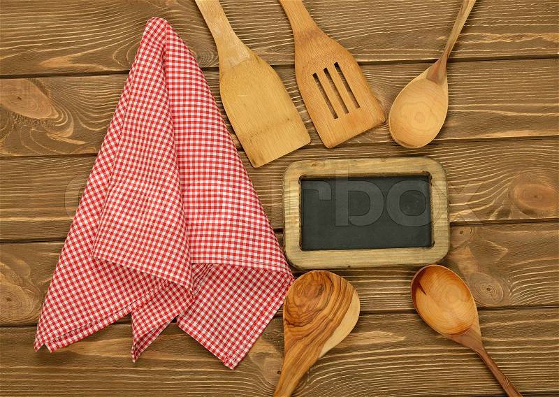 Writing board napkin and spoon on brown background, top view, stock photo
