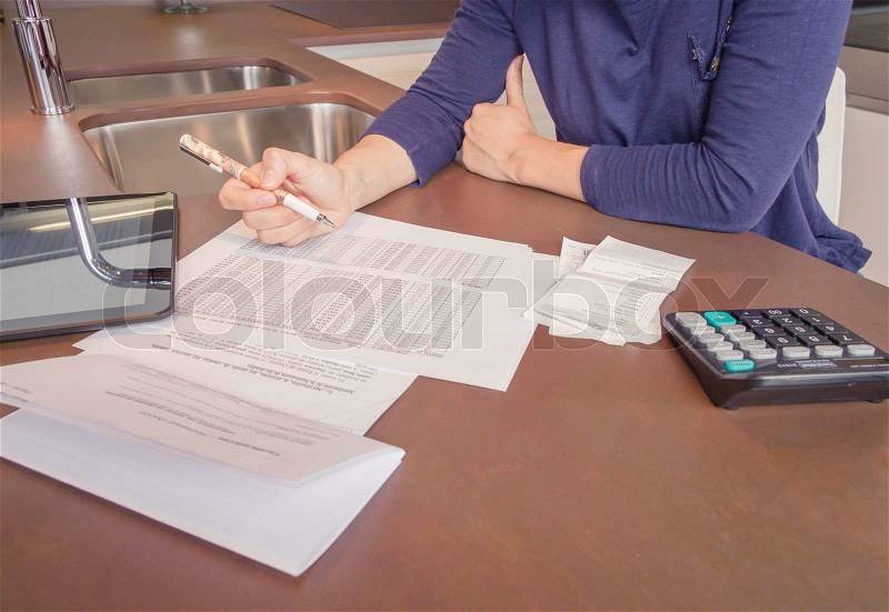Unemployed and divorced woman with many debts reviewing her monthly bills, stock photo