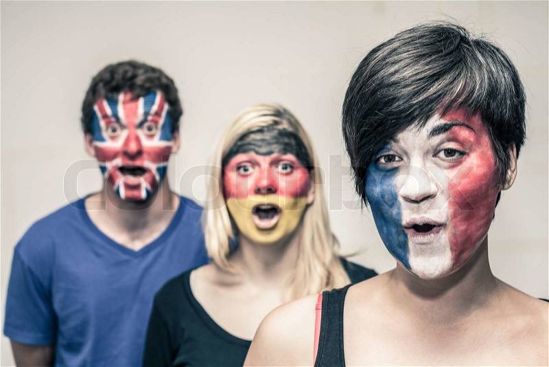 Group of surprised happy people with painted flags on their faces, stock photo