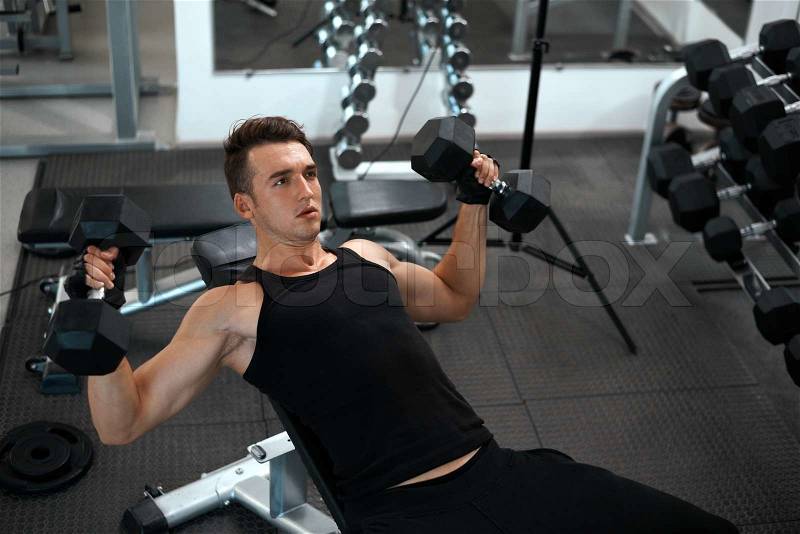 Man exercising in trainer for pectoral muscles in the gym, stock photo
