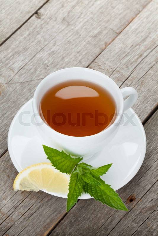 Green tea with lemon and mint on wooden table background with copy space, stock photo