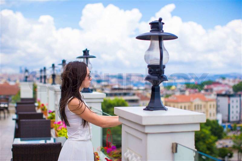 Young beautiful woman on the restaurant terrace with a stunning view of the city, stock photo