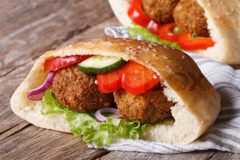 Falafel with vegetables in pita bread closeup on wooden table horizontal , stock photo
